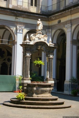 Колодец с небольшой мраморной статуей св