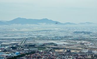 Самолет над полями заходит на посадку в 