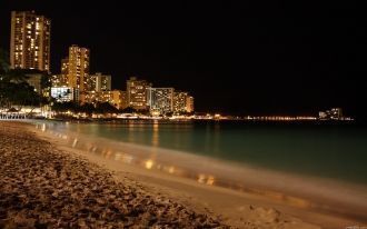 Пляж города ночью.