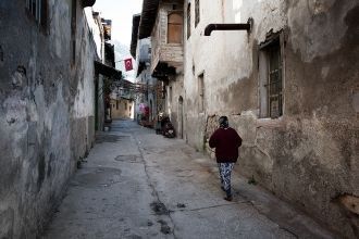 Местная жительница идет по узкой улице А