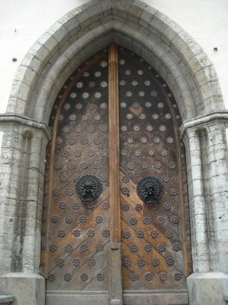 Массивные двери снабжены бронзовыми ручк