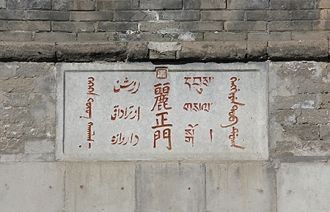 Табличка над центральным порталом Ворот 