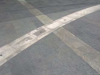 В асфальте напротив входа в небоскреб см