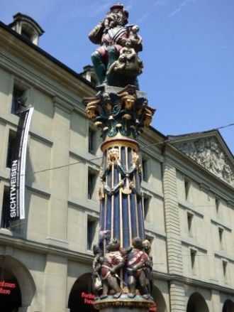 Колонну окружают изображения, шествующих