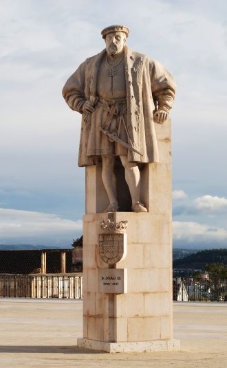 На площади стоит статуя Жоао III, за спи