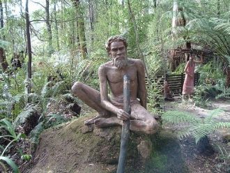 Абориген, сидящий на камне.