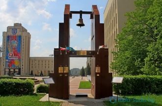 Слева от входа в костел стоит колокол На