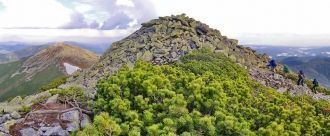 Вершина горы укрыта сизо-серыми камнями,