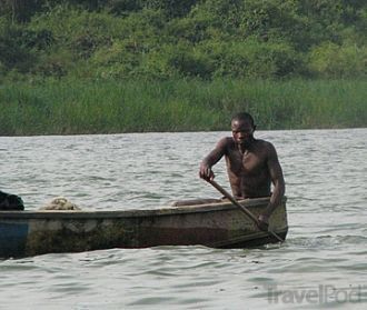 Местный житель плывет на лодке по озеру 