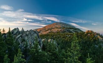 Нижняя часть вершины покрыта лесами, поэ